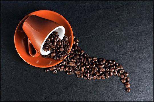 omgevallen kopje op schotel met koffiebonen
